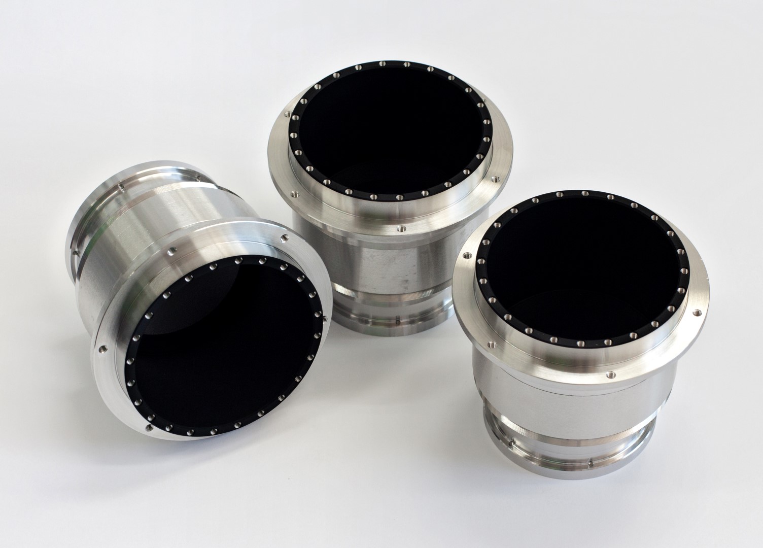 3 circular metallic components coated with acktar’s Vacuum Black coating